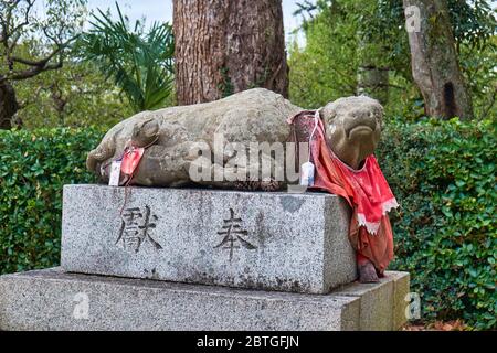 KYOTO, GIAPPONE - 17 OTTOBRE 2019: La statua di pietra del bue sdraiato nel bib rosso, il messaggero animale (otsukai) del Dio Tenjin (Sugawara Michizane) a Ki Foto Stock