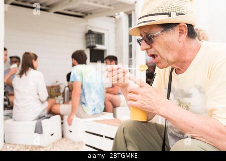 Cabo Polonio, Rocha / Uruguay; 30 dicembre 2018: Uomo turistico che prova una bevanda rinfrescante surgelata di butia, un frutto nativo della zona Foto Stock