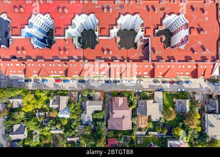 vista aerea dall'alto verso il basso dei tetti degli edifici di appartamenti e delle case private nella zona residenziale della città Foto Stock