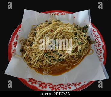 Spaghetti fritti con salsa piccante o spaghetti fritti con pollo tritato e basilico santo su vassoio, cibo in stile tailandese Foto Stock