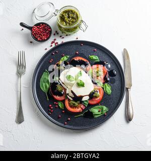 insalata caprese italiana con pomodori ciliegini kumato al pepe nero. Primo piano. Vista superiore quadrata. Foto Stock