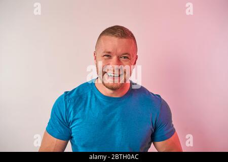 un uomo con gomma da masticare in bocca su uno sfondo chiaro Foto Stock