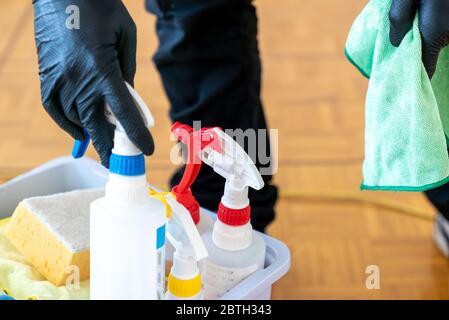 Un detergente professionale per vetri che rimuove i materiali di consumo da un secchio e tiene un panno in microfibra Foto Stock