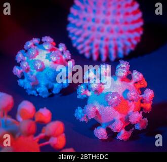 immagine di alcuni colorati virus simbolici illuminati sul retro scuro Foto Stock