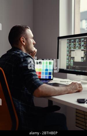 Bell'uomo freelance che lavora a distanza da casa. Giovane maschio che lavora sul suo computer Foto Stock