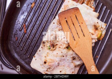 lo shaverma in lacais fatto in casa poggia su un cucchiaio di legno alla griglia Foto Stock