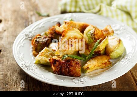 Zucchine arrostite su un piatto bianco Foto Stock