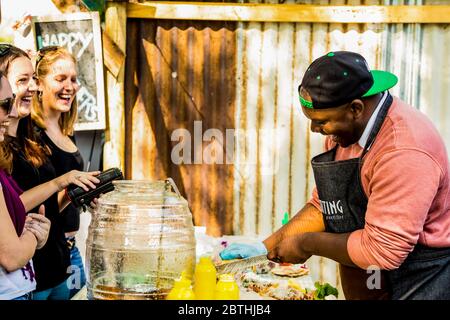 Johannesburg, Sudafrica - 24 maggio 2015: African Male vendor Take out food at outdoor stalls at Farmer's market Foto Stock