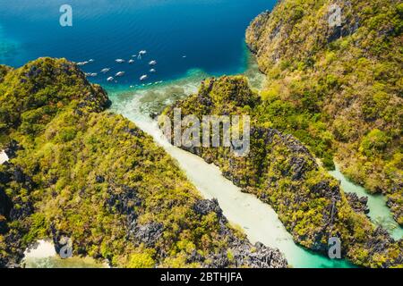 Palawan, Filippine vista aerea dell'isola tropicale di Miniloc. Gita turistica barche ormeggiate all'ingresso della grande laguna Foto Stock