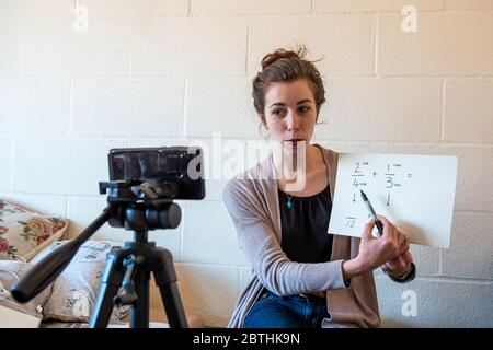 Gli insegnanti della scuola sono costretti ad insegnare le loro lezioni da casa online virtualmente utilizzando i loro telefoni per video se stessi sotto covid-19 coronavirus UK USA Foto Stock