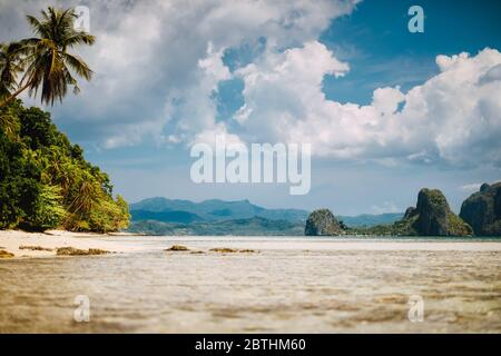 El Nido, Palawan, Filippine. Paesaggio tropicale scenico di laguna poco profonda, spiaggia sabbiosa con palme. Isole esotiche e paesaggi bianchi Foto Stock