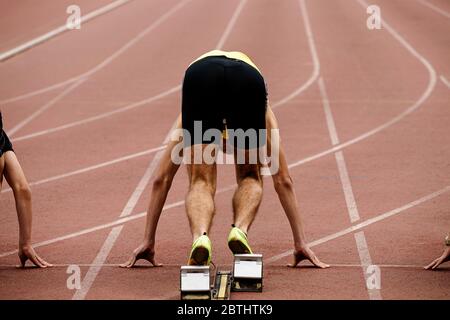 Runner sprinter in blocchi di partenza al comando SET per 100 metri di gara Foto Stock