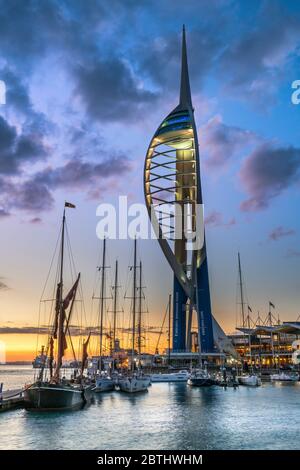 Dopo una calda ed umida giornata di Hampshire costa, le luci si accendono al Gunwharf Quays come il sole tramonta su Portsmouth Porto sul Solent e f Foto Stock