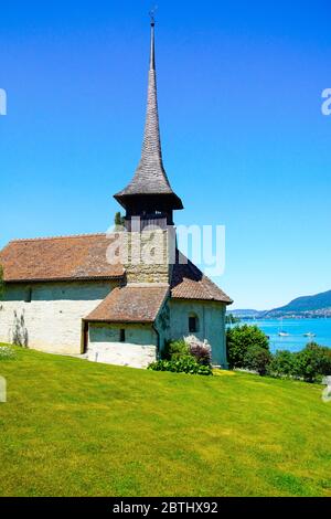 La chiesa del villaggio di Einingen è idilliamente situata sulle rive del lago Thun (Thunersee). Oberland Bernese, Berna, Svizzera. Foto Stock