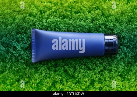 tubo di crema blu scuro. Giacente su muschio verde. Vista dall'alto Foto Stock