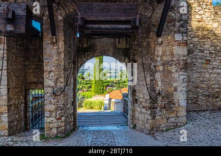 Brescia, Italia, 11 settembre 2019: Muro di pietra con merli e ponte levatoio porta del castello medievale di Brescia o Castello di Brescia o Falcon d'Italia, centro storico, Lombardia Foto Stock