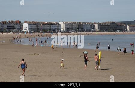La gente gode il tempo caldo sulla spiaggia di Weymouth in Dorset, poichè la gente è ricordata praticare l'allontanamento sociale durante il buon tempo e il rilassamento delle restrizioni di blocco. Foto Stock