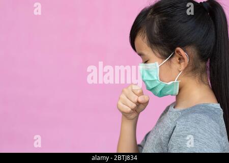 Bambina asiatica con maschera igienica per prevenire il virus, PM2.5, Coronavirus, (2019-nCoV). Ragazza asiatica che si sente malata e tosse isolata Foto Stock