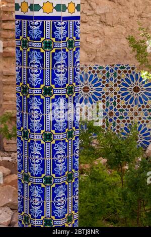 Parte ben conservata di un complesso abbandonato. Cortile con piastrelle tradizionali motivi floreali sulla colonna decorativa e sulla parte di un muro nel backg Foto Stock