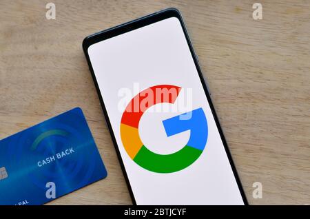 California, Stati Uniti, 2020. Piatto con logo Google su uno schermo mobile e una carta di credito cashback su sfondo di legno. Foto Stock