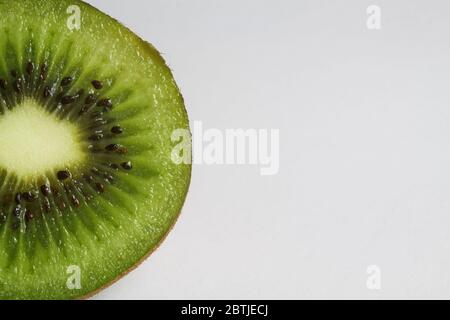 Macro primo piano di kiwifuit verde maturo isolato a metà fette con sfondo bianco e spazio per la copia del testo Foto Stock