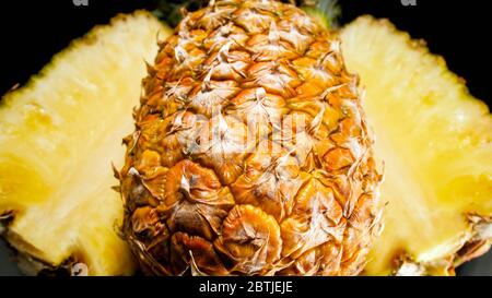 Immagine closeup di pezzi di ananas su sfondo nero. Sfondo astratto di frutti tropicali esotici Foto Stock