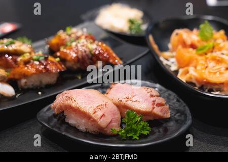 Nigiri con bruccia di tonno, bruciatura di tonno sushi, piatti giapponesi su piatto di ceramica, piatti giapponesi, menù giapponese, tonno sushi, sushi maguro su fondo piatto, sel Foto Stock