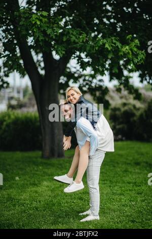 Giovane coppia interracial ha un divertimento, giochi e risate nel parco. Il concetto di relazioni d'amore e di unità tra diverse razze umane. Foto Stock