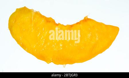 Immagine di un closeup isolato della fetta di pesca al succo su sfondo bianco. Sfondo astratto di bacche e frutti. Foto Stock