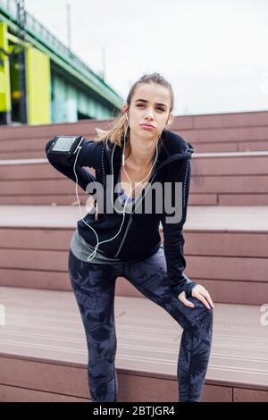 Giovane donna in abbigliamento sportivo che soffre di mal di schiena dopo l'allenamento Foto Stock