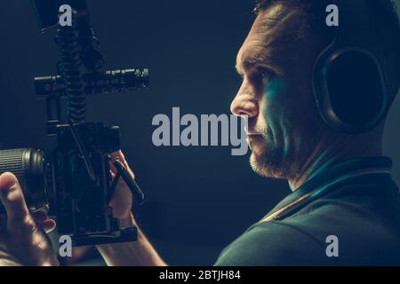 Tema Motion Picture. Operatore di telecamere con dispositivo di registrazione digitale professionale in mano. Foto Stock