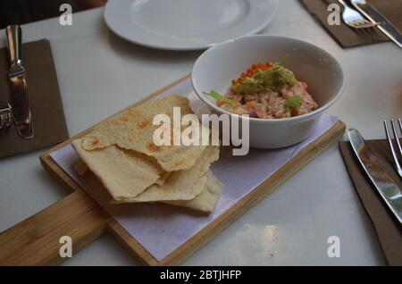 Tartaro di salmone con uova di salmone e avocado con cracker al ristorante spagnolo di tapas, Barcellona. Foto Stock