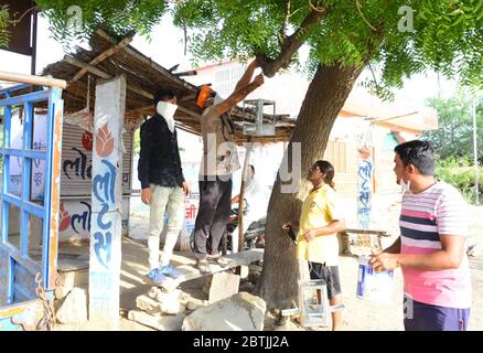 Beawar, India. 24 maggio 2020. Volontari di Shri RAM Sena appende l'alimentatore di uccelli su albero come vasi d'acqua 'Parindaa' per gli uccelli nella stagione estiva, in corso in tutta la nazione COVID-19 blocco, a Beawar, Rajasthan. (Foto di Sumit Saraswat/Pacific Press) Credit: Pacific Press Agency/Alamy Live News Foto Stock