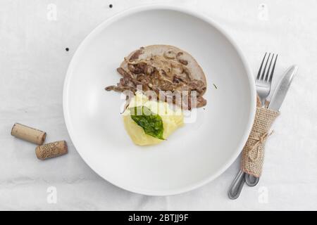 Un pasto di stroganoff di manzo con purè di patate e pomodoro. Decorata con timo e rosmarino. Su bianco Foto Stock