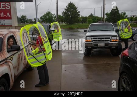 Manhattan, Kansas, Stati Uniti. 25 Maggio 2020. JAYLEE LAYTON, a sinistra, prende un ordine Chick-fil-a mentre indossa una capanna impermeabile durante una tempesta di pioggia il Memorial Day. Credit: Luke Townsend/ZUMA Wire/Alamy Live News Foto Stock