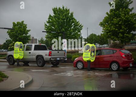 Manhattan, Kansas, Stati Uniti. 25 Maggio 2020. I dipendenti di Chick-fil-a indossano capanne impermeabili per prendere gli ordini durante una tempesta di pioggia il Memorial Day. Credit: Luke Townsend/ZUMA Wire/Alamy Live News Foto Stock