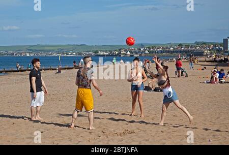 Portobello, Edimburgo, Scozia, Regno Unito. 26 maggio 2020. Atmosfera più rilassata al mare nel tardo pomeriggio, quando la Scozia si avvicina alla fine della fase 1 di Coronavirus Lockdown. Temperatura di 19 gradi e soleggiata. Questi amici possono giocare a pallavolo. Foto Stock