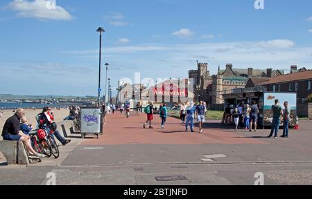 Portobello, Edimburgo, Scozia, Regno Unito. 26 maggio 2020. Atmosfera più rilassata al mare nel tardo pomeriggio, quando la Scozia si avvicina alla fine della fase 1 di Coronavirus Lockdown. Temperatura di 19 gradi e soleggiata. Le persone si rilassano sul lungomare e si accodano al pulmino con spuntini. Foto Stock