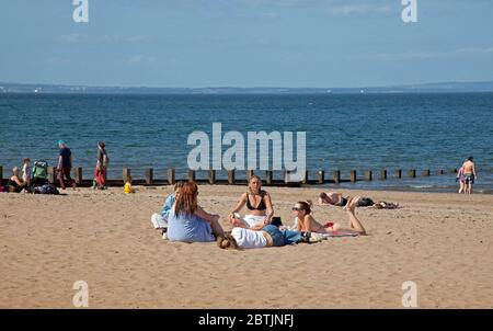 Portobello, Edimburgo, Scozia, Regno Unito. 26 maggio 2020. Atmosfera più rilassata al mare nel tardo pomeriggio, quando la Scozia si avvicina alla fine della fase 1 di Coronavirus Lockdown. Temperatura di 19 gradi e soleggiata. Le persone si divertono a sedersi sulla spiaggia sabbiosa con meno apprensione di essere spostati. Foto Stock