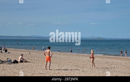 Portobello, Edimburgo, Scozia, Regno Unito. 26 maggio 2020. Atmosfera più rilassata al mare nel tardo pomeriggio, quando la Scozia si avvicina alla fine della fase 1 di Coronavirus Lockdown. Temperatura di 19 gradi e soleggiata. Le persone si divertono a sedersi sulla spiaggia sabbiosa con meno apprensione di essere spostati. Foto Stock