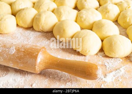 Il perno con farina e prova su tavola di legno. Preparazione per la cottura del prodotto culinario Foto Stock