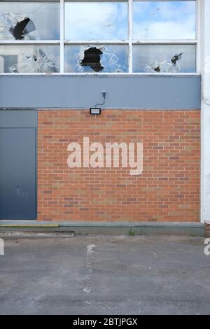 edificio commerciale abbandonato con finestre rotte Foto Stock