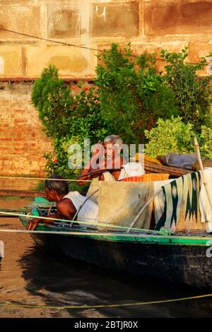 India, Varanasi - Uttar Pradesh stato, 31 luglio 2013. All'alba, due barcaioli riposano sulla loro barca sulle rive del Gange. Foto Stock