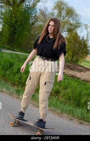 La giovane ragazza corre su una strada di campagna in natura verde Foto Stock