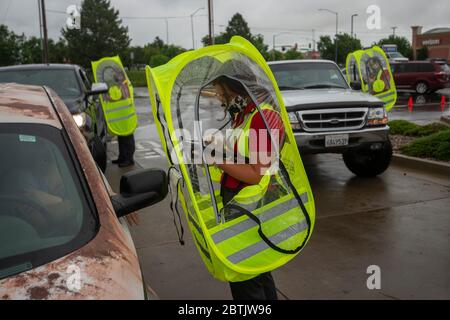 Manhattan, Kansas, Stati Uniti. 25 Maggio 2020. JAYLEE LAYTON, centro e altri dipendenti di Chick-fil-a indossare capanne impermeabili per prendere ordini durante una tempesta di pioggia il Memorial Day. Credit: Luke Townsend/ZUMA Wire/Alamy Live News Foto Stock