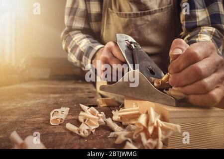 Le mani di un falegname lavorano con una pialla Foto Stock
