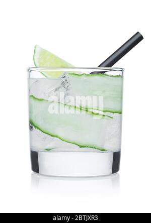 Cocktail di calice in vetro con cubetti di ghiaccio e paglia, cetriolo e fetta di lime su sfondo bianco. Foto Stock