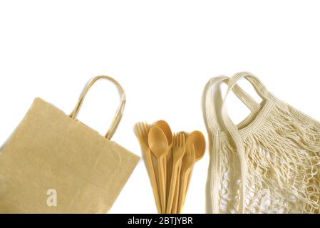 Borsa per la spesa in rete di cotone e carta con molti cucchiai, forchette e coltelli isolati su sfondo bianco. Borsa per la spesa. Zero rifiuti, senza plastica Foto Stock