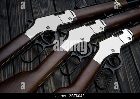 Cowboy si riga su uno sfondo di legno. Fucili d'epoca del selvaggio West. Armi di cowboy, sceriffi e banditi. Foto Stock