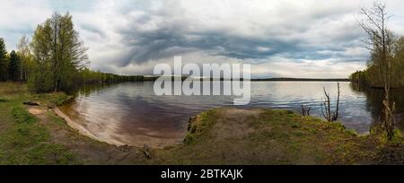 Nuvole soffici con pioggia galleggiano nel cielo sul grande lago . Vsevolozhsk, Leningrad Region.Panorama. Foto Stock